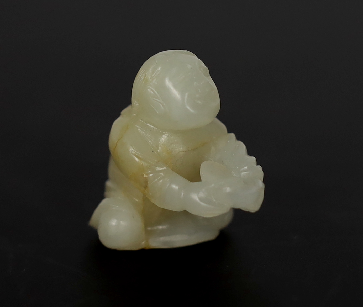 A Chinese white and russet carved jade figure of Liu Hai, 17th century